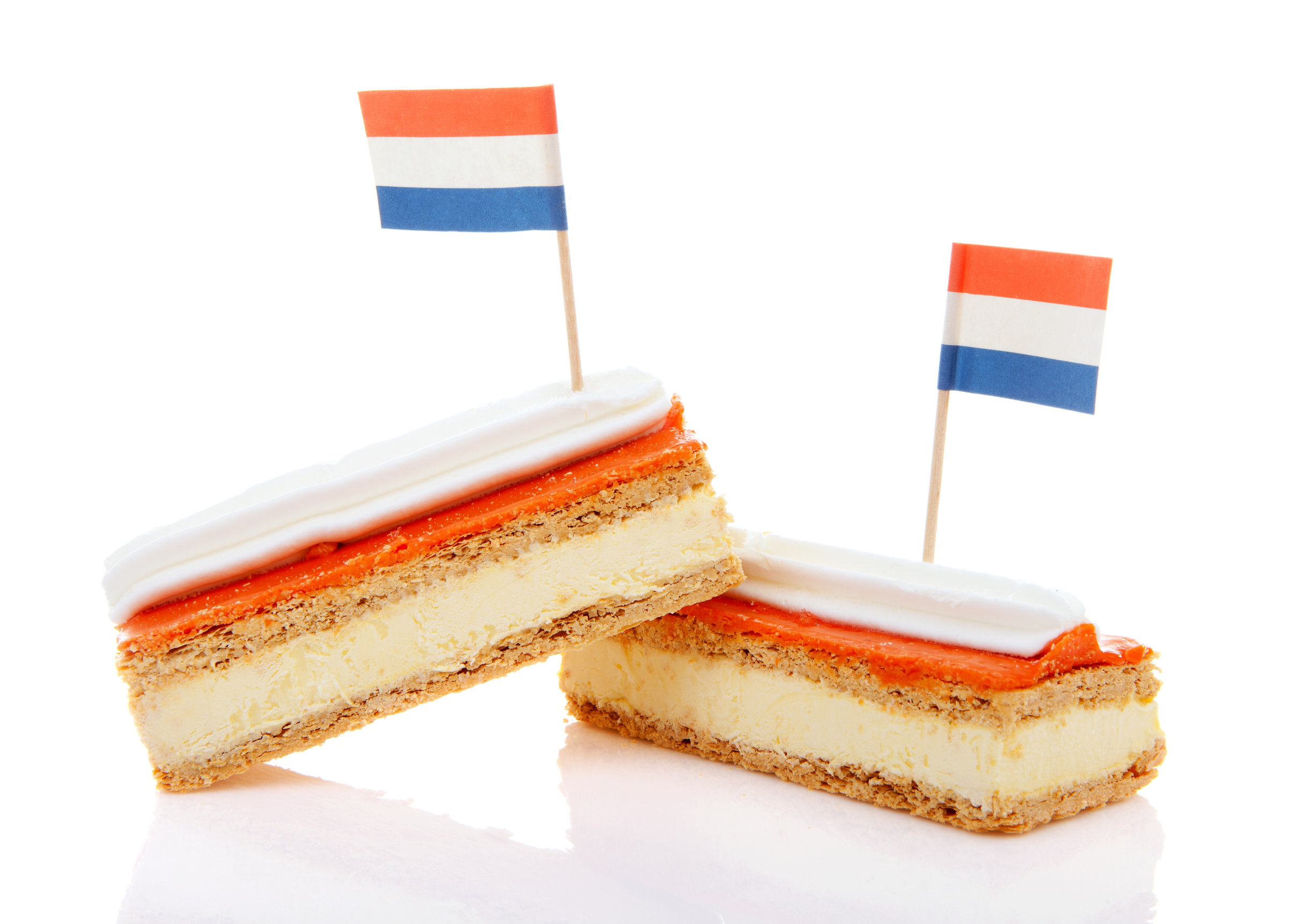 Two Traditional Dutch Pastry Called Tompouce With Flags Over White Background